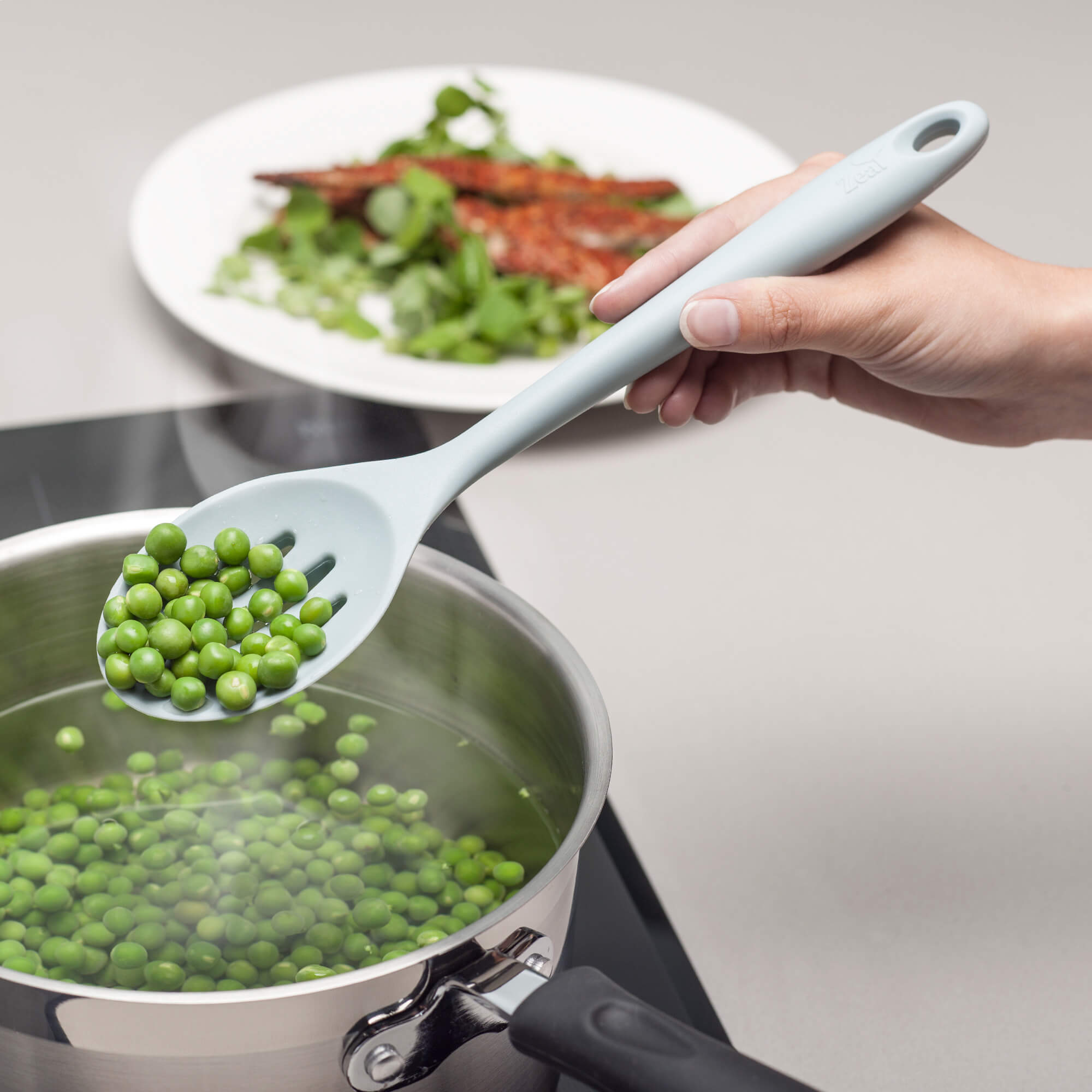 Using a Zeal Silicone Slotted Spoon to drain peas
