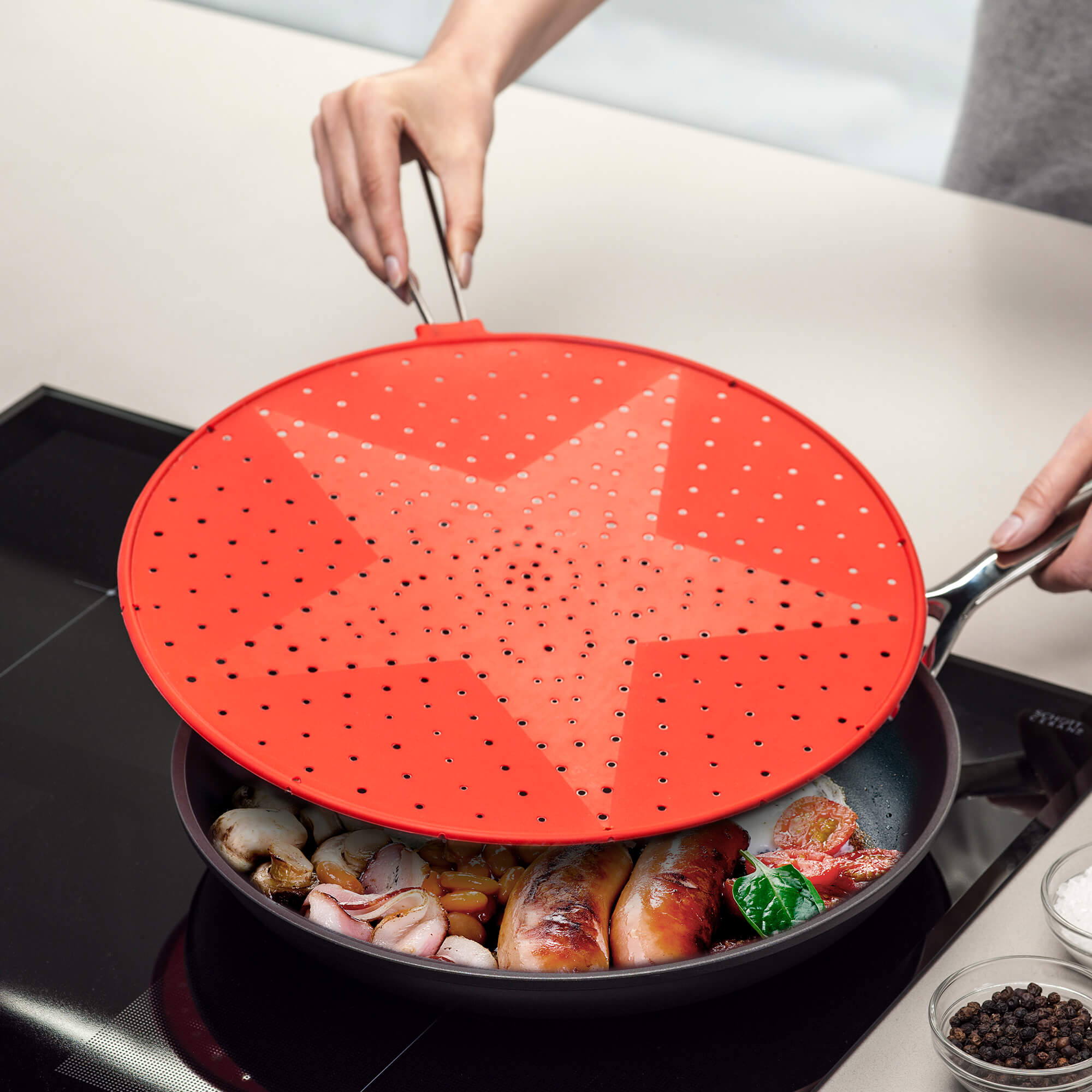 Zeal Red No Splash Silicone Splatter Guard in use when cooking
